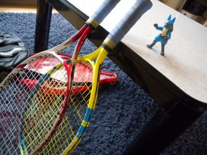two tennis rackets leaning on a bench