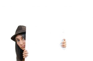 Woman looking from behind a wall