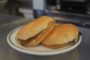 two squashed cheesburgers on a plate