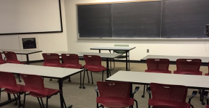 Photo of desks and chalkboard in a classroom.
