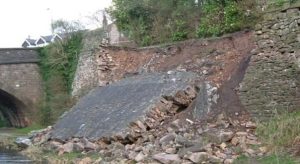 Photo of an outdoor scene, a large wall has broken free and slid downhill.