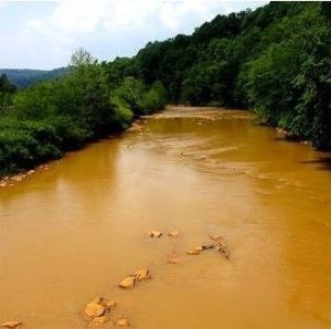Photograph of a river containing yellow-colored water