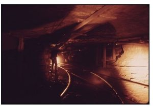 Photograph of train tracks running in a dark tunnel