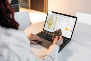 Woman sitting at a table with a laptop shopping online.