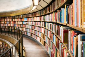 Books on brown wooden shelf. A library.